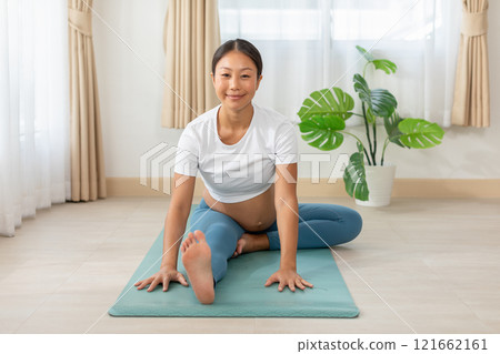 Pregnant woman practicing yoga at home 121662161