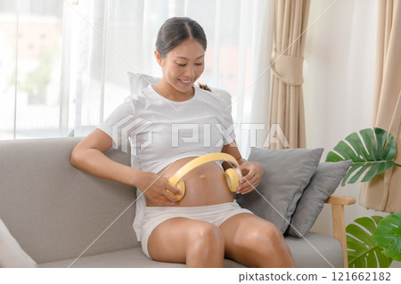 cheerful Asian pregnant woman lounges comfortably cheerful Asian pregnant woman lounges comfortably 121662182