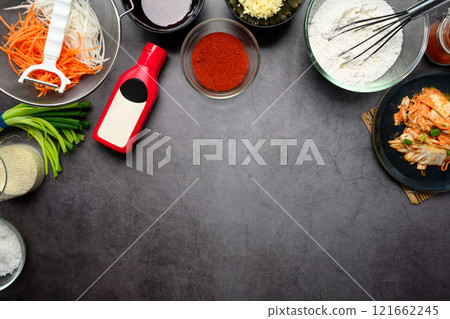 Essential ingredients for making kimchi, fresh vegetables, seasoning and sauces on a dark textured background 121662245