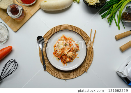 Traditional Korean Kimchi on a rustic Plate accompanied by wooden chopsticks. Korean cuisine and traditional side dish concept 121662259