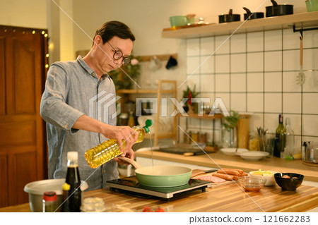 Middle aged man preparing a delicious meal with fresh ingredients in a kitchen Middle aged man preparing a delicious meal with fresh ingredients in a kitchen 121662283