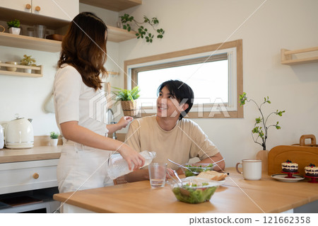 Couple enjoying breakfast and conversation in a cozy kitchen Couple enjoying breakfast and conversation in a cozy kitchen 121662358