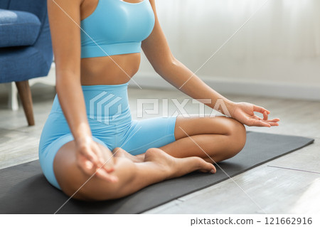 Asian woman finding peace and balance through yoga practice in the comfort of her home. Promoting wellness, mindfulness, and self care. Perfect for yoga and home wellness concepts 121662916
