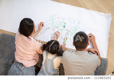 Heartwarming scene of Asian family spending quality time together at home. The father, mother, and their young daughter are lying on the floor Heartwarming scene of Asian family spending quality time together at home. The father, mother, and their young daughter are lying on the floor 121663201