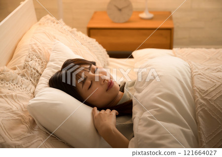 一名婦女在間接照明下熟睡的側面影像。 一名婦女在間接照明下熟睡的側面影像。 121664027