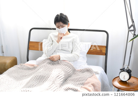 Unwell Asian woman coughing in bed Unwell Asian woman coughing in bed 121664806