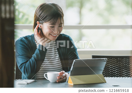 Woman on terrace with digital gadget 121665918
