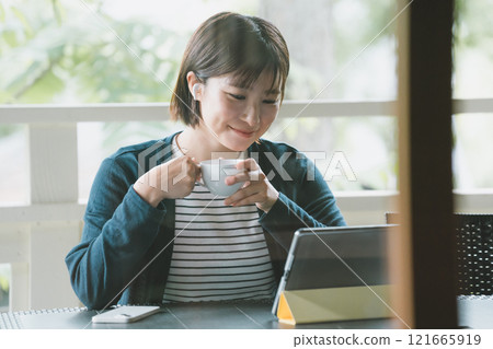 Woman on terrace with digital gadget Woman on terrace with digital gadget 121665919