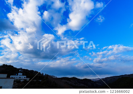 A cold wind blowing evening at Nara Nunome Dam in the New Year: White clouds floating against the clear blue sky and a mountain range in the distance② 121666002