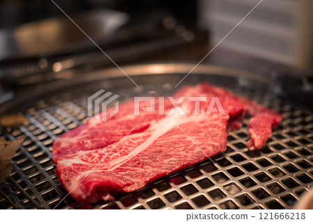 A close-up shot of premium cuts of marbled Hanwoo beef, Korean Style Meat on the Grill. BBQ rare meat with soft focus A close-up shot of premium cuts of marbled Hanwoo beef, Korean Style Meat on the Grill. BBQ rare meat with soft focus 121666218