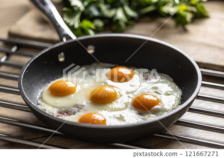 English breakfast on a pan. Ham and eggs sprinkled with parsley 121667271