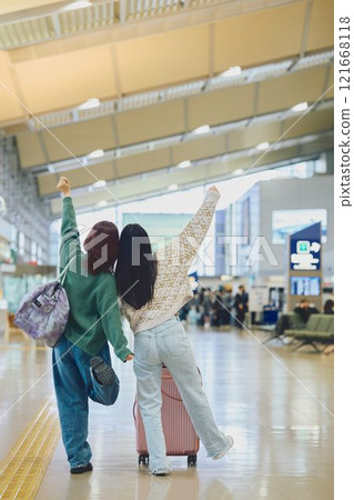 Two women walking through the airport 121668118