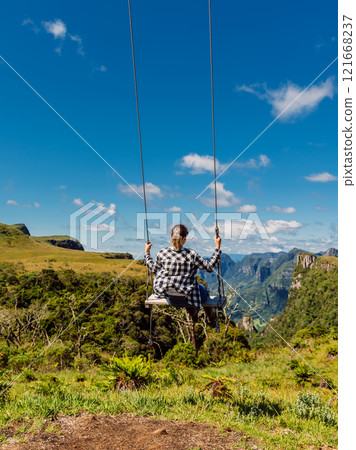 Woman on a swing in scenic Canyon park in Santa Catarina, Brazil. 121668237