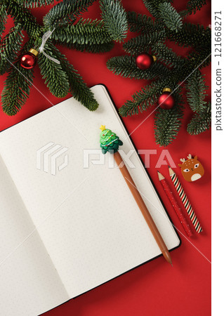 Flat Lay Christmas notes with open notepad and holiday pencils on a red background with fir branches. A place for your text. Flat Lay Christmas notes with open notepad and holiday pencils on a red background with fir branches. A place for your text. 121668271