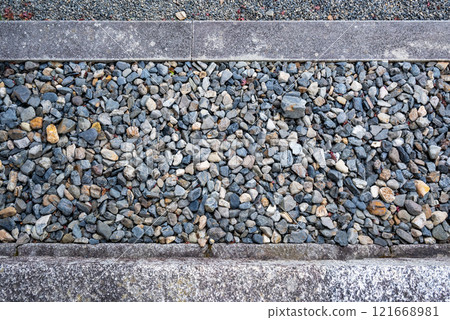 Stones embedded in concrete ground 121668981