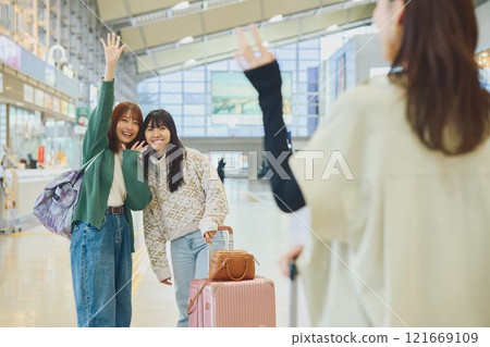 A woman welcoming a friend at the airport A woman welcoming a friend at the airport 121669109
