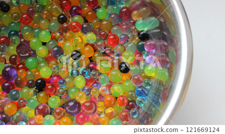 Colorful Gel Balls Inside Metal Bowl On White Surface Colorful Gel Balls Inside Metal Bowl On White Surface 121669124