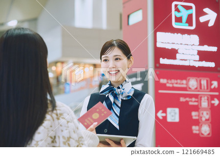 A woman receiving guidance from ground staff at the airport 121669485