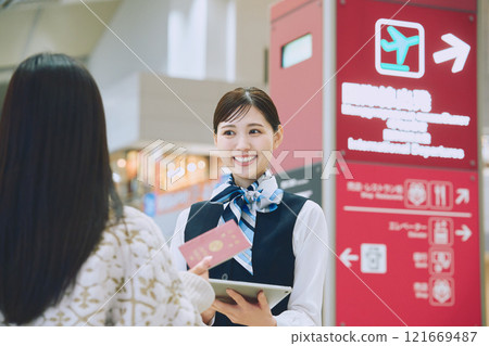 一名婦女在機場接受地勤人員的指導 121669487