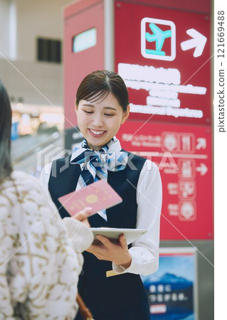一名婦女在機場接受地勤人員的指導 一名婦女在機場接受地勤人員的指導 121669488