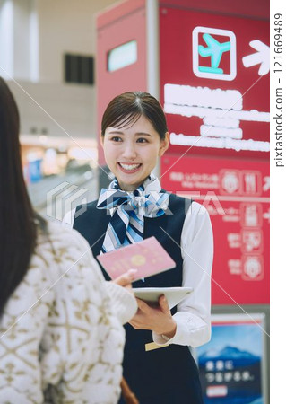 A woman receiving guidance from ground staff at the airport 121669489