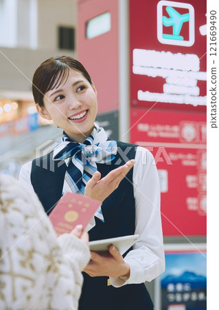 一名婦女在機場接受地勤人員的指導 一名婦女在機場接受地勤人員的指導 121669490