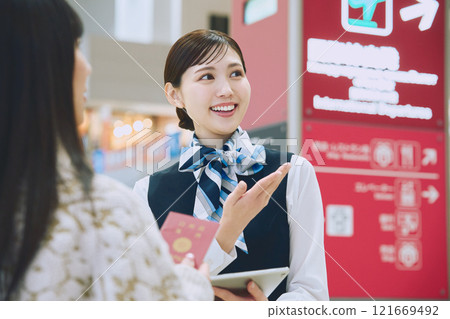 A woman receiving guidance from ground staff at the airport 121669492