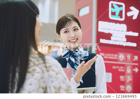 A woman receiving guidance from ground staff at the airport 121669493
