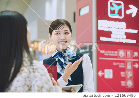 一名婦女在機場接受地勤人員的指導 121669496