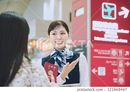 一名婦女在機場接受地勤人員的指導 一名婦女在機場接受地勤人員的指導 121669497