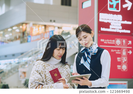 A woman receiving guidance from ground staff at the airport A woman receiving guidance from ground staff at the airport 121669498