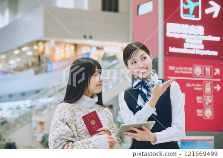 A woman receiving guidance from ground staff at the airport A woman receiving guidance from ground staff at the airport 121669499