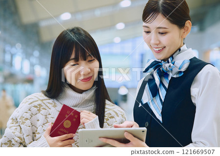 一名婦女在機場接受地勤人員的指導 一名婦女在機場接受地勤人員的指導 121669507