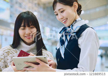 A woman receiving guidance from ground staff at the airport A woman receiving guidance from ground staff at the airport 121669513