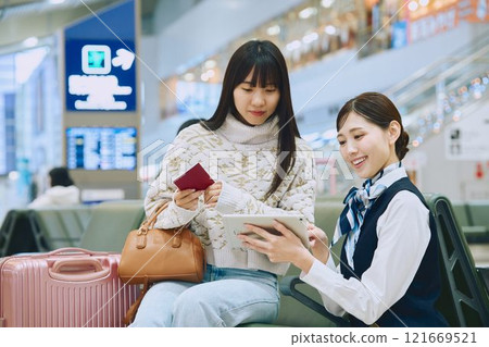 A woman receiving guidance from ground staff at the airport A woman receiving guidance from ground staff at the airport 121669521