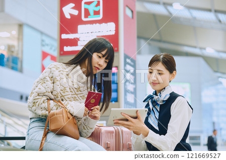 A woman receiving guidance from ground staff at the airport 121669527