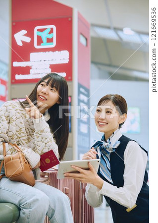 A woman receiving guidance from ground staff at the airport 121669536