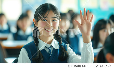 Smiling female student raising her hand 01 121669692