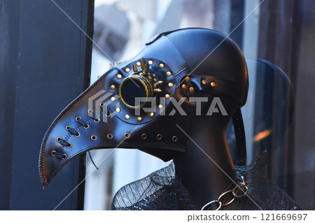 A masked mannequin plague doctor in shop window, closeup of headgear 121669697