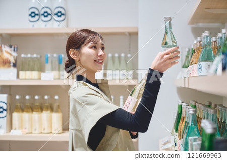 一位女士在商店挑選酒類 攝影由今吉清酒釀酒廠提供。 121669963