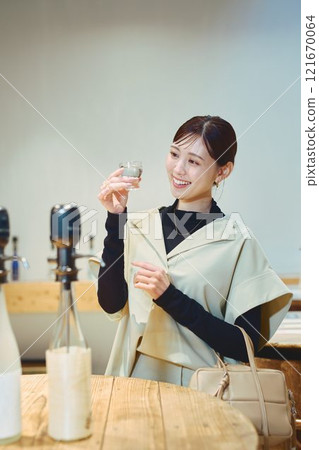 一位女士正在品嚐酒。 121670064