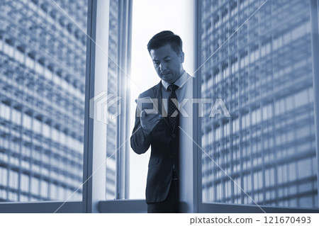 asian business man looking at cellphone in office 121670493