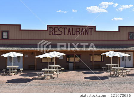 Empty benches and tables under beige sun umbrellas near a vintage restaurant in a US national park Empty benches and tables under beige sun umbrellas near a vintage restaurant in a US national park 121670626