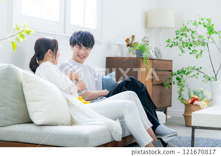 A young couple relaxing in the living room A young couple relaxing in the living room 121670817