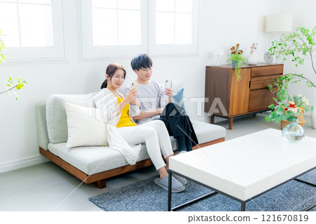 看一台智能手機的年輕夫婦在客廳 121670819