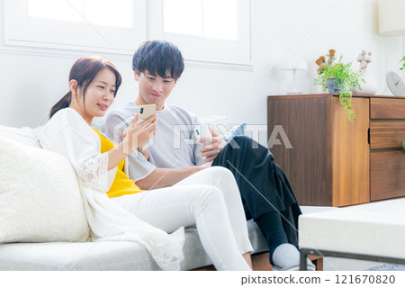 看一台智能手機的年輕夫婦在客廳 121670820