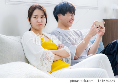 Boyfriend looking at smartphone, angry girlfriend 121670825