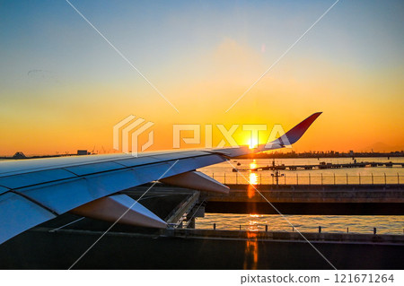 Sunset seen from an airplane, airplane wing Sunset seen from an airplane, airplane wing 121671264