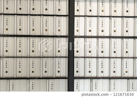 A wall adorned with a row of post boxes, each awaiting mail and messages from its recipients. A wall adorned with a row of post boxes, each awaiting mail and messages from its recipients. 121671630