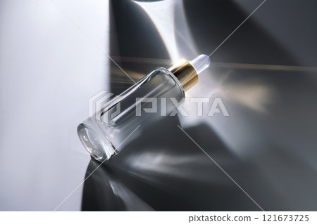 Bottle of face serum with a pipette with a beautiful highlight. Bottle of face serum with a pipette with a beautiful highlight. 121673725